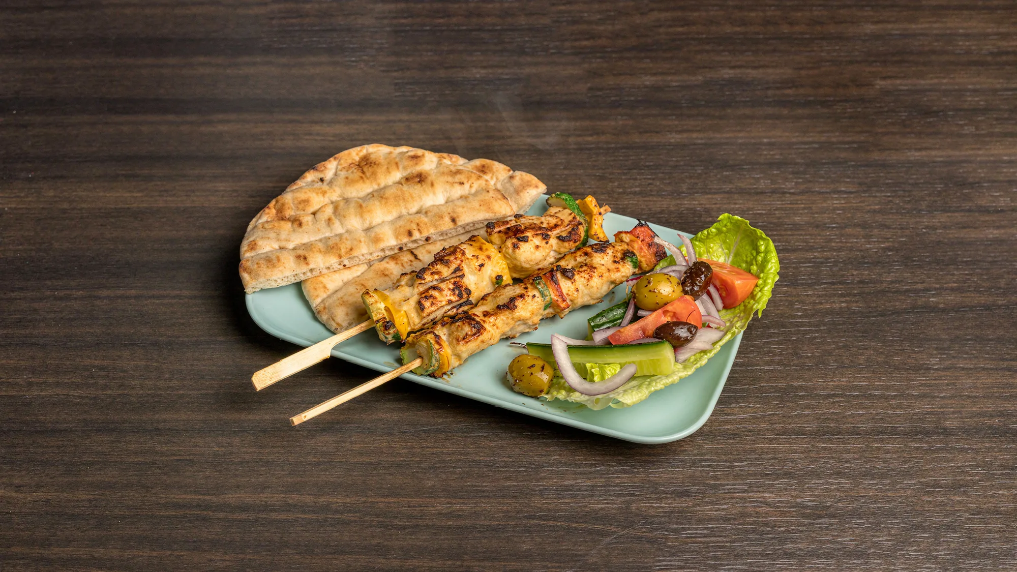 Chicken souvlaki with peppers, zucchini, pita and salad